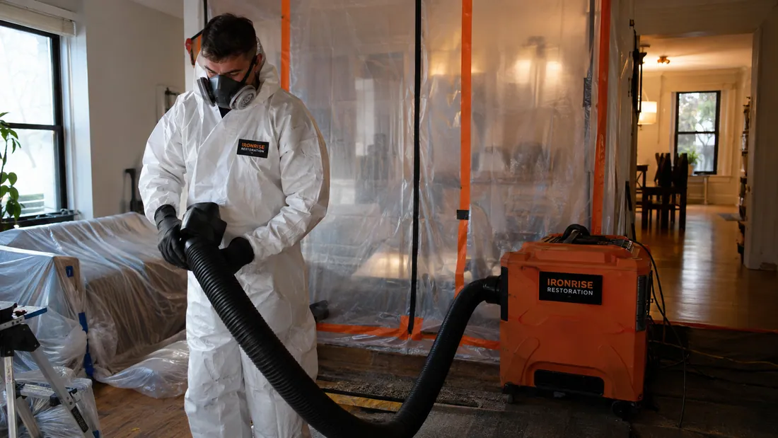 Ironrise technician reviewing a contained mold-remediation area and the affected building materials.